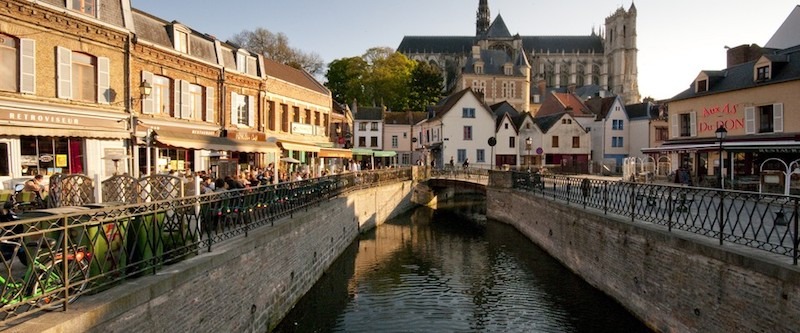 Amiens Glisy : Canal pittoresque avec café et église.