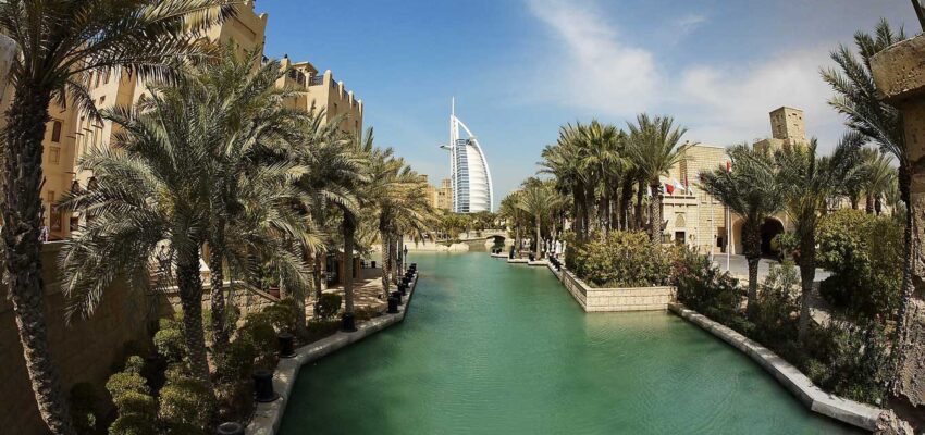 Hôtel Burj Al Arab ; canal et palmiers en arrière-plan.