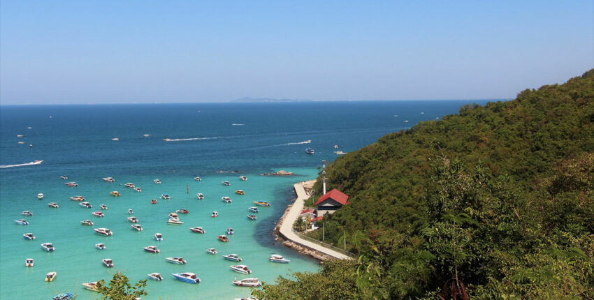 Littoral turquoise, bateaux, verdure luxuriante aux alentours.