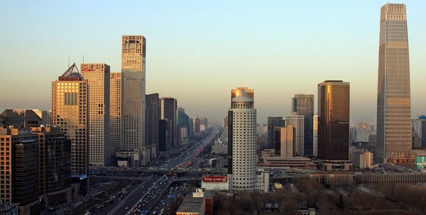 Coucher de soleil sur un paysage urbain : hauts gratte-ciels, autoroute très fréquentée.
