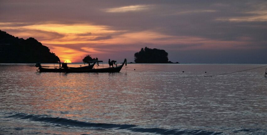Silhouettes de bateaux au coucher du soleil.