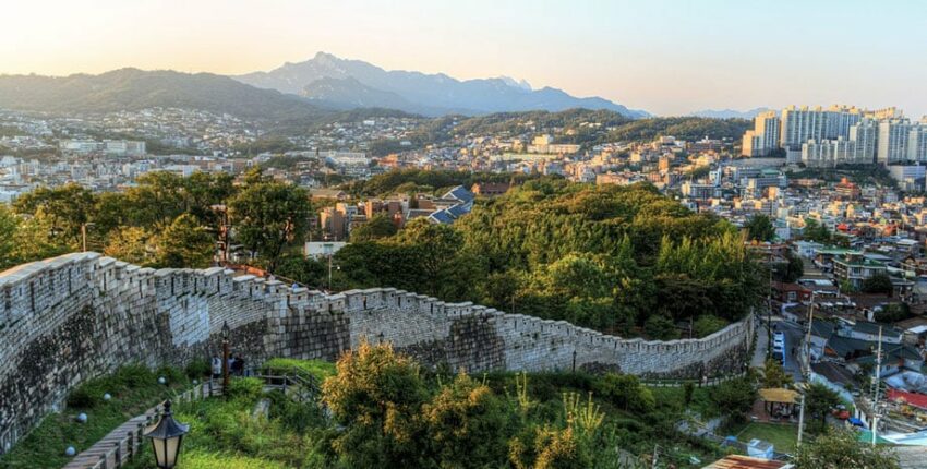 Vue panoramique sur la ville, mur historique avec montagnes.