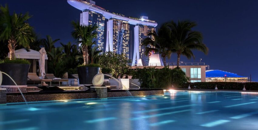 Hôtel luxueux : Piscine à débordement en scène de nuit.