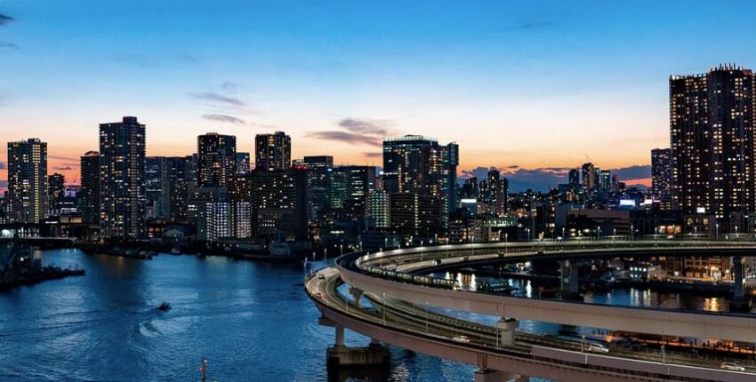 Skyline ville crépuscule, route courbe sur rivière.