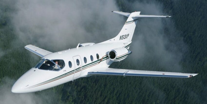 **Texte alternatif:**  
Location de jet privé, BEECHJET 400 survole une forêt.