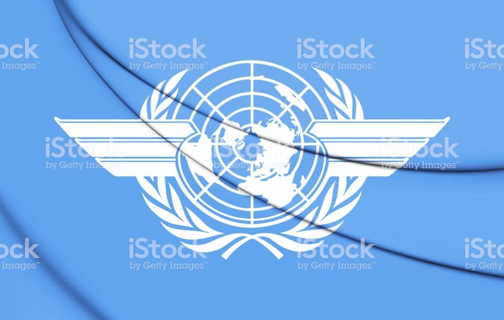 Emblème UN sur fond bleu avec carte mondiale.
