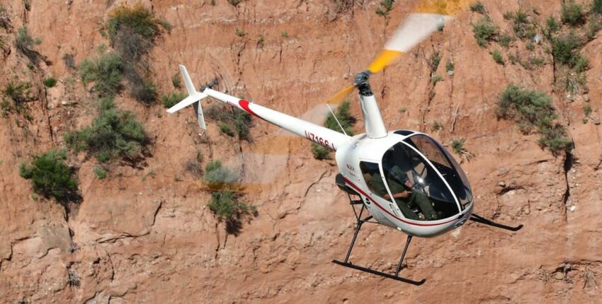location jet privé : Robinson R22 près d'une falaise rocheuse