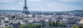 Vue aérienne Paris Seine ponts Tour Eiffel ciel partiellement nuageux.