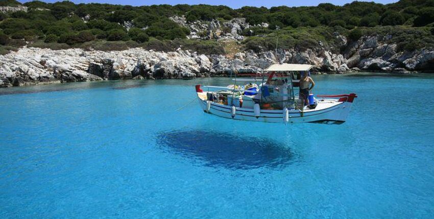 bateau de pêcheur au milieu de l'eau translucide